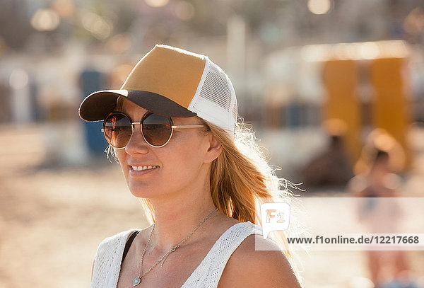Porträt einer Frau am Strand  mit Sonnenbrille und Mütze  Sitges  Katalonien  Spanien