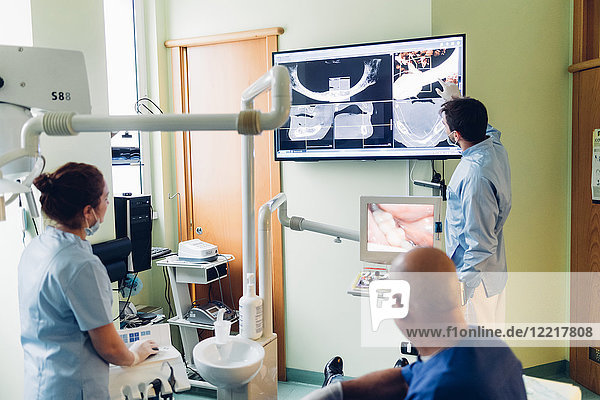Dentist and dental nurse looking at dental x-rays