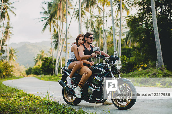 Junges Ehepaar fährt Motorrad auf einer Landstraße  Krabi  Thailand