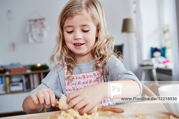 Young girl rolling out cookie dough  dough stuck to rolling pin