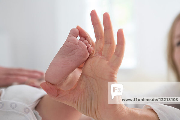 Frau hält den nackten Fuß des kleinen Sohnes  Nahaufnahme