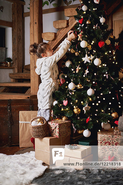 Junges Mädchen schmückt Weihnachtsbaum
