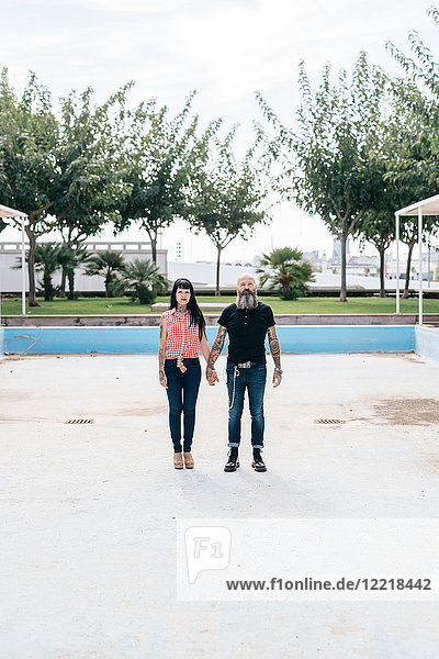 Reifes Hipster-Paar im leeren Schwimmbad stehend  Porträt  Valencia  Spanien