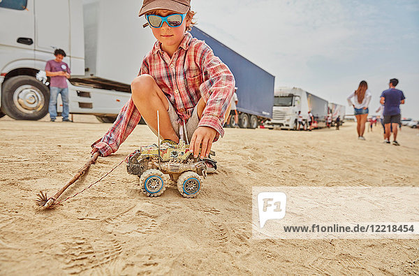 Junge spielt mit Spielzeuglastwagen im Sand  Ica  Peru