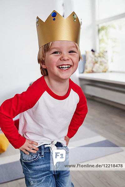 Porträt eines Jungen  der eine Pappkrone trägt und lächelt