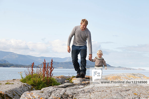 Man and son strolling by fjord  Aure  More og Romsdal  Norway