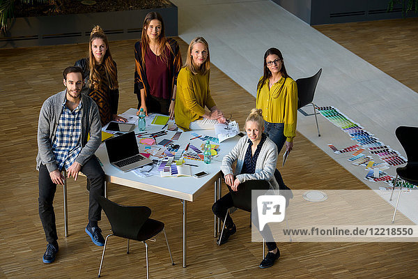 Team of male and female designers by design studio table  high angle portrait