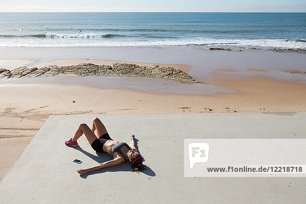 Junge Frau auf dem Rücken liegend am Strand  Carcavelos  Lissabon  Portugal  Europa
