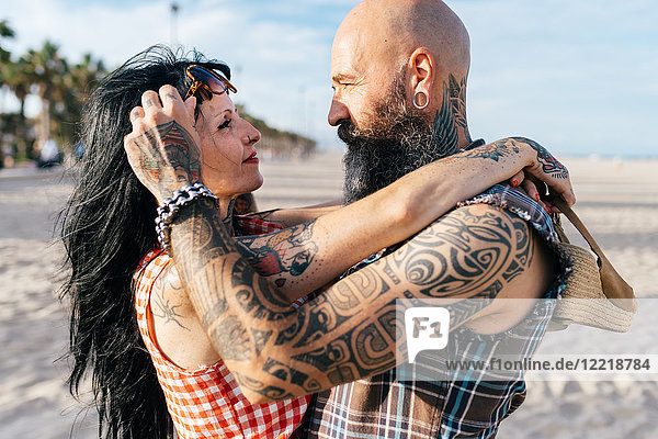 Mature tattooed hipster couple face to face on beach  Valencia  Spain
