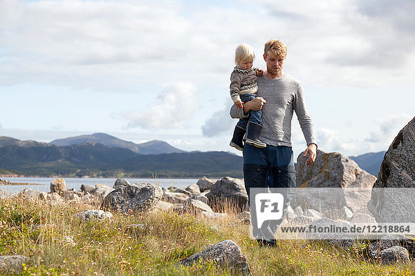 Man carrying son by fjord  Aure  More og Romsdal  Norway