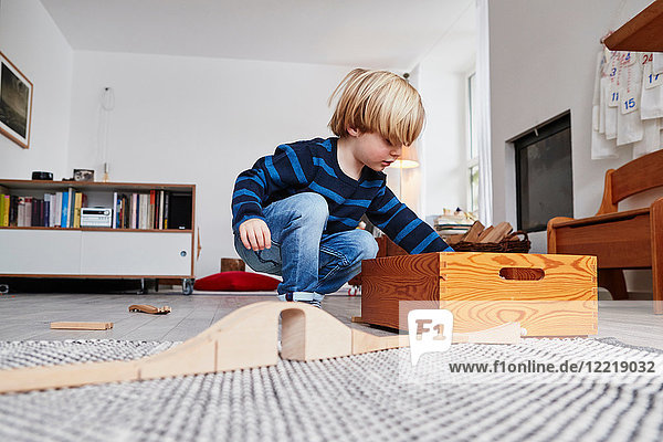 Young boy playing with toys in living room  low angle view