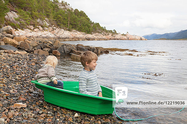 Jungen in grünem Boot am Ufer des Fjords  Aure  More og Romsdal  Norwegen