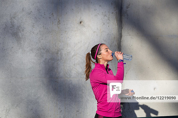 Junge Frau trinkt Wasser aus einer Wasserflasche
