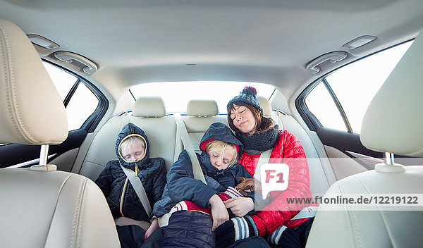 Mother and children sleeping in car