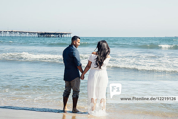 Paar am Strand stehend  Hände haltend  Rückansicht  Seal Beach  Kalifornien  USA