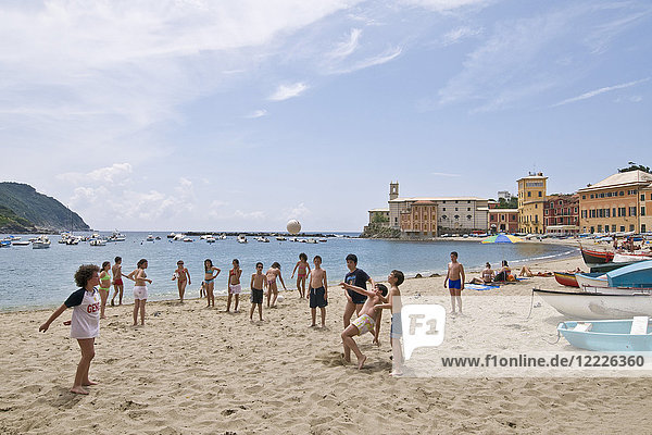 Kids playing with the ball at the beach of Bay of Silence  Sestri Levante  Liguria  Italy