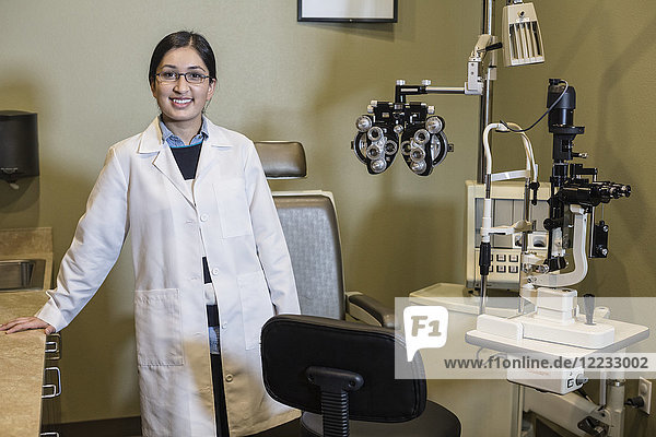 An Asian woman ophthalmologist in her office examination room.
