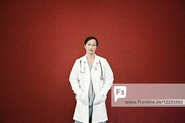Asiatische Ärztin im Laborkittel mit Stethoskop.