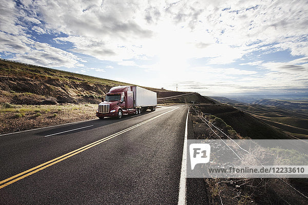 Kommerzieller Lastwagen fährt durch das hohe Wüstenland im Osten Washingtons  USA