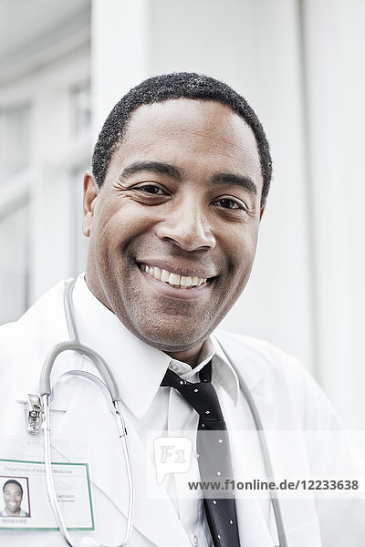 Schwarzer Mann Arzt im Laborkittel mit Stethoskop.