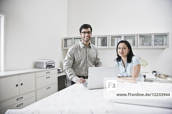 Hispanic man and woman working together in an architect's office.