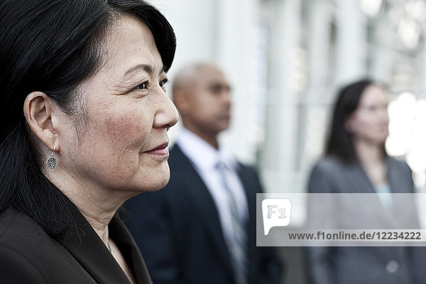 Close-up of Asian business woman in a group of people.