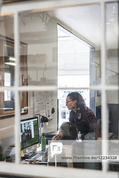 Zwei Frauen schauen auf den Computerbildschirm im Bürobereich der Metallwerkstatt.