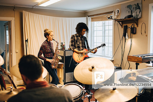 Freunde beim Spielen von Musikinstrumenten im Studio