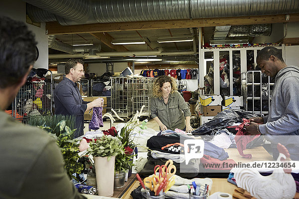 Multiethnische Freiwillige untersuchen Textilien im Lagerhaus