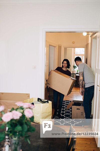 Mann und Frau mit Kisten im neuen Haus stehend