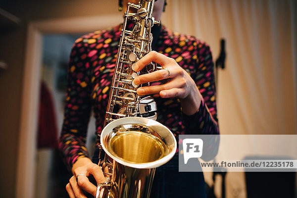 Mittelteil der Frau beim Saxophonspielen im Studio