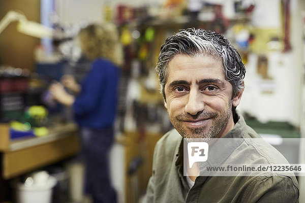 Porträt eines lächelnden reifen männlichen Freiwilligen im Workshop