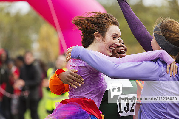 Enthusiastic female runners finishing charity run  celebrating