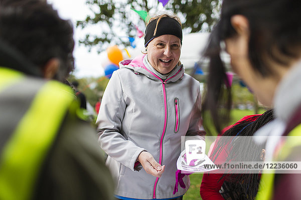 Lächelnde Frau mit Marathon-Lätzchen beim Benefizlauf