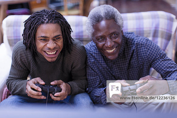 Glücklicher Großvater und Enkel beim Videospiel