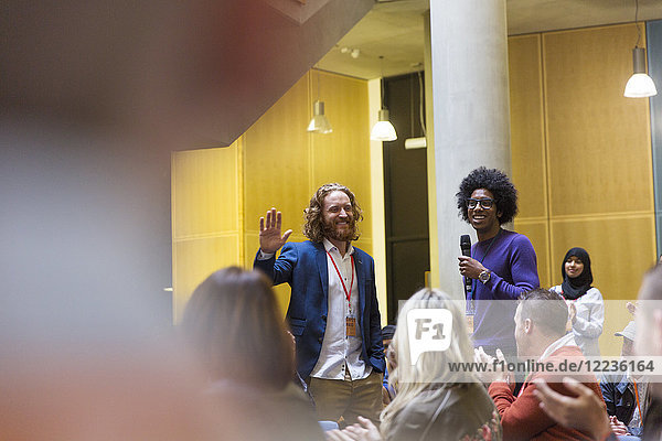 Conference audience clapping for male speakers