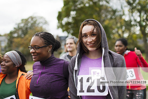 Portrait smiling female runner at charity run in park