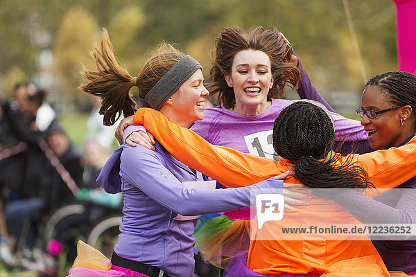 Enthusiastic female runners finishing charity run  celebrating