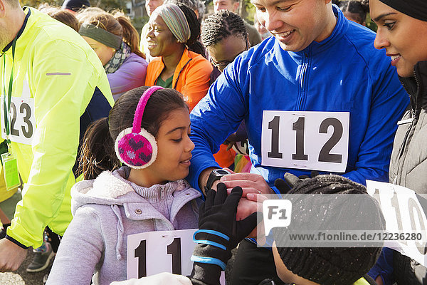 Familienläufer beim Start des Charity-Laufs auf intelligente Uhr achten