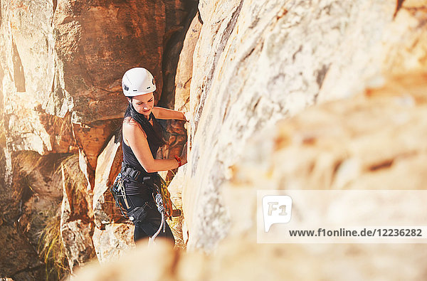 Female rock climber climbing rock