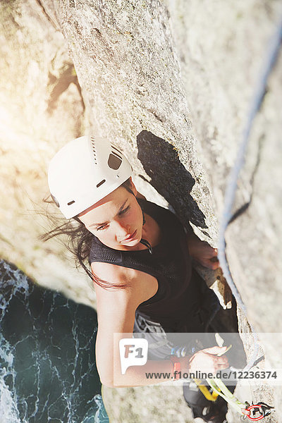 Determined  focused female rock climber scaling rock