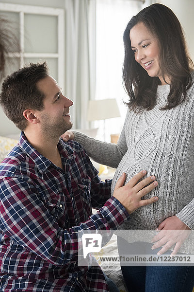 Schwangere Frau und Partner schauen sich an