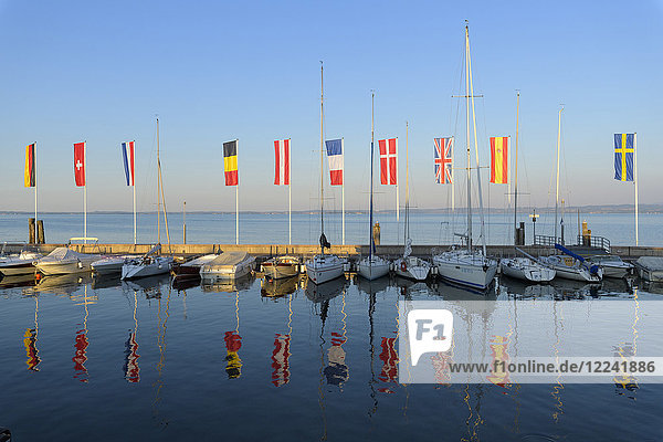 Row of boats and colorful European flags in the harbor marina on Lake Garda (Lago di Garda) at Bardolino in Veneto  Italy