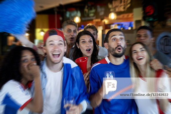 Französische Fußballfans schauen Fußballspiel im Fernsehen in der Kneipe an