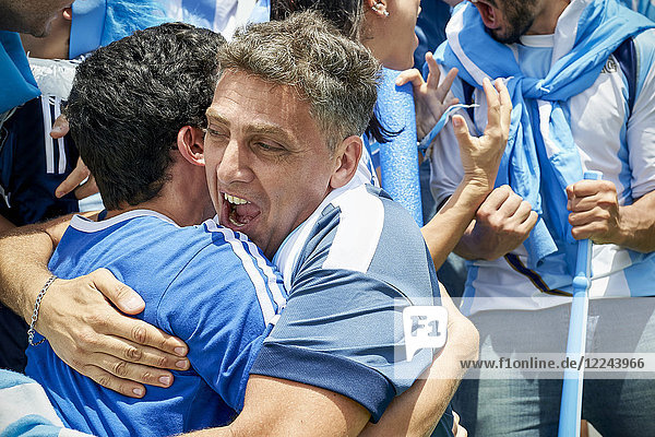 Argentinische Fußballfans umarmen sich beim Fußballspiel