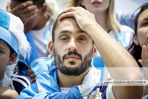 Argentinischer Fußballfan hält Hand auf Kopf in Enttäuschung beim Spiel