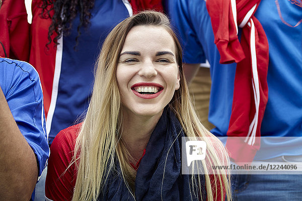 Woman watching football match  smiling cheerfully