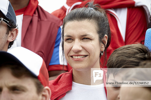 Woman smiling cheerfully at football match