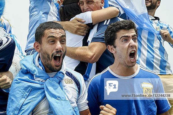 Argentinische Fußballfans schreien beim Zuschauen des Fußballspiels