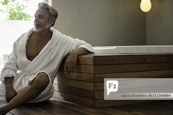 Mann im Bademantel entspannt im Saunaraum